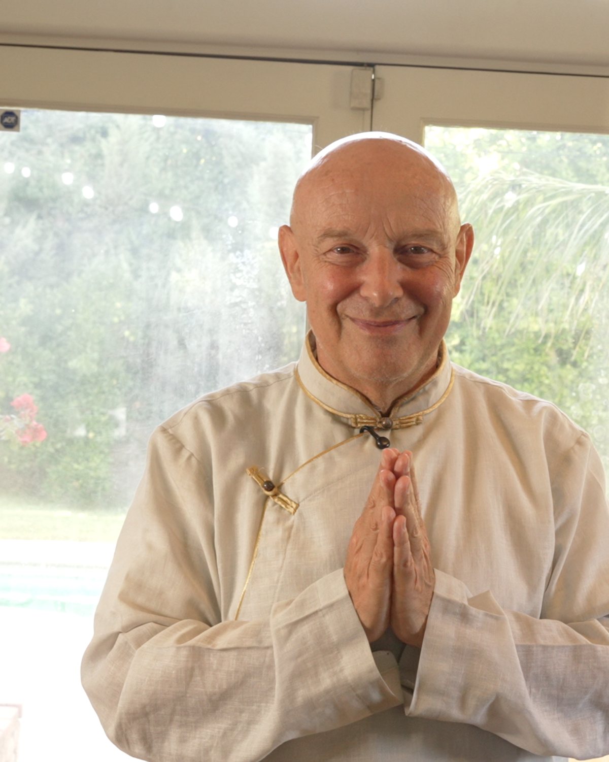 Michel Pascal in a pale linen shirt with his hands pressed together